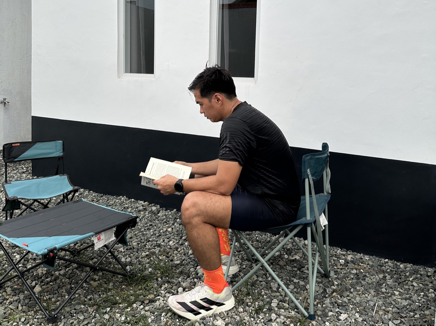 John Arce reading a book outdoors during a break from training