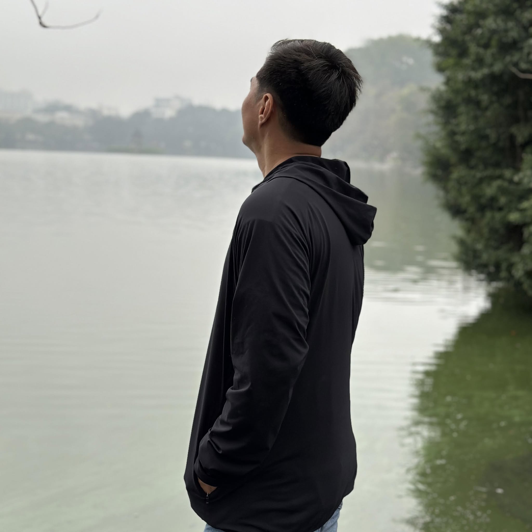 John Arce looking out over a lake, back turned to the camera